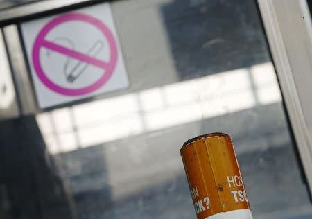 A public ashtray is pictured in front of a sign marking a no-smoking zone in Vienna April 10, 2015. REUTERS/Heinz-Peter Bader