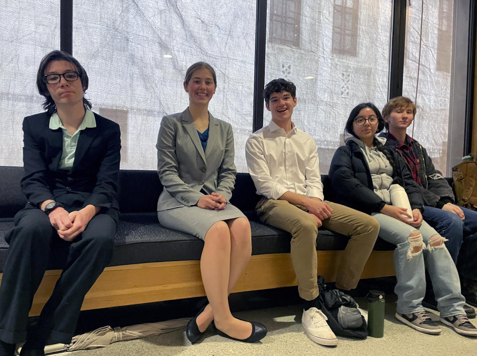 High school students sit on a bench at the Oregon State Capitol building in Salem, Ore., Thursday, March 9, 2023, before testifying at a hearing in support of a bill that would require climate change instruction in public schools from kindergarten through 12th grade. If passed, the bill would make Oregon only the second state to require climate instruction by law. (AP Photo/Claire Rush)