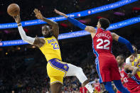 Los Angeles Lakers' LeBron James, left, passes the ball with Philadelphia 76ers' Matisse Thybulle, right, defending during the first half of an NBA basketball game, Saturday, Jan. 25, 2020, in Philadelphia. (AP Photo/Chris Szagola)