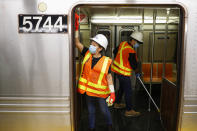 Contractors clean subway cars at the 96th Street station to control the spread of COVID-19, Thursday, July 2, 2020, in New York. Mass transit systems around the world have taken unprecedented — and expensive — steps to curb the spread of the coronavirus, including shutting down New York subways overnight and testing powerful ultraviolet lamps to disinfect seats, poles and floors. (AP Photo/John Minchillo)