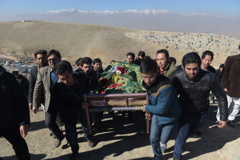 Afghan mourners carry the coffin of Saeed Jawad Hossini, 29, who was killed in a suicide attack on a minibus carrying employees of Afghan TV channel TOLO in Kabul on January 21, 2016