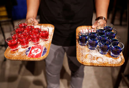 Special red and blue shots offered at Escobar bar to mark the summit meeting between U.S. President Donald Trump and North Korean leader Kim Jong Un, are brought to a table in Singapore June 4, 2018. REUTERS/Edgar Su