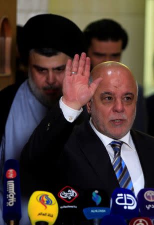 Iraqi Prime Minister Haider al-Abadi, who's political bloc came third in a May parliamentary election, attends a news conference with Iraqi Shi'ite cleric Moqtada al-Sadr, who's bloc came first, in Najaf, Iraq June 23, 2018. REUTERS/Alaa al-Marjani