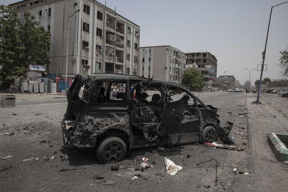 A destroyed vehicle remains at the site of a deadly attack on the Sheikh Othman police station in Aden, Yemen, Thursday, Aug. 1, 2019. Yemen's rebels have fired a ballistic missile at a military parade in the southern port city of Aden as coordinated suicide bombings targeted the police station in another part of the city. The attacks killed over 50 people and wounded dozens. (AP Photo/Nariman El-Mofty)