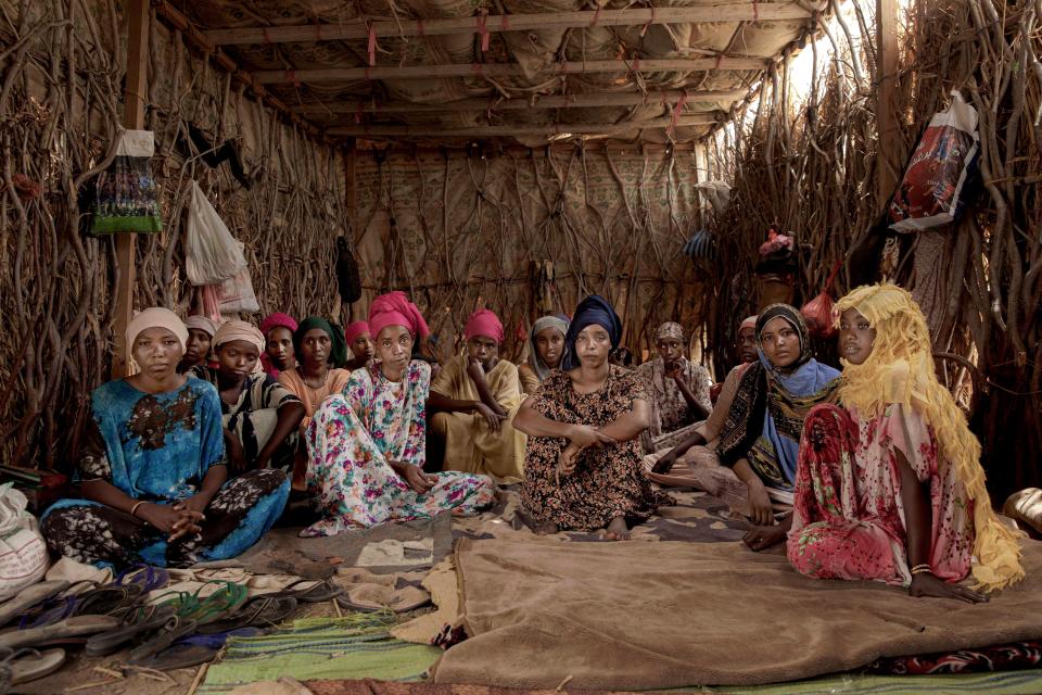 In this July 25, 2019 photo, Ethiopian migrant girls sit inside in a lockup known in Arabic as a "hosh," in Ras al-Ara, Lahj, Yemen. Some lockups hold as many as 50 women at a time. The women will stay here for several days until their transportation is ready. (AP Photo/Nariman El-Mofty)