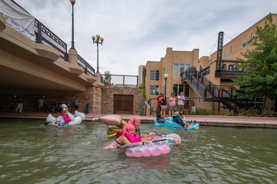 Three teams race to the finish line of the build-your-own boat race during the inaugural Riverfest at the Pueblo Riverwalk on Saturday, August 20, 2022.