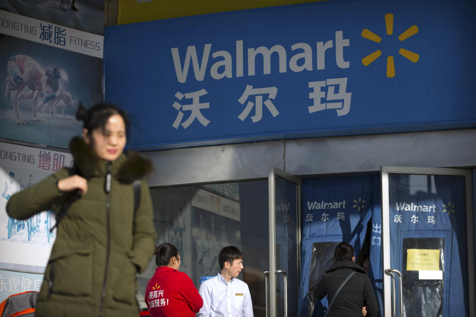 People walk past a Walmart store in Beijing, China, Wednesday, Dec. 6, 2017. (AP Photo/Mark Schiefelbein)