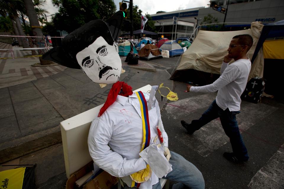 Un monigote que sus autores buscaron representar al presidente Nicolás Maduro fue instalado en una banca en un campamento levantado por los opositores fuera del edificio local de las Naciones Unidas en Caracas, Venezuela, el jueves 24 de abril de 2014.