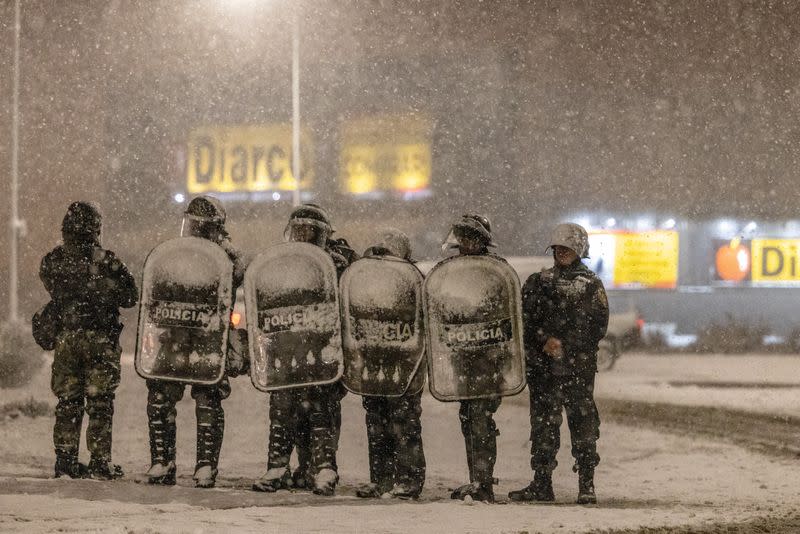 Police forces guard an area after local residents attempted to loot a supermarket in the southern town of Bariloche, Patagonia Region