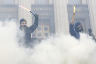 <p>Participants burn flares outside the building of the Ukrainian Parliament (Verkhovna Rada) during the so-called March of Dignity, held by activists of nationalist groups and their supporters and marking the third anniversary of the 2014 Ukrainian pro-European Union (EU) mass protests, in Kiev, Ukraine, Feb. 22, 2017. (Valentyn Ogirenko/Reuters) </p>