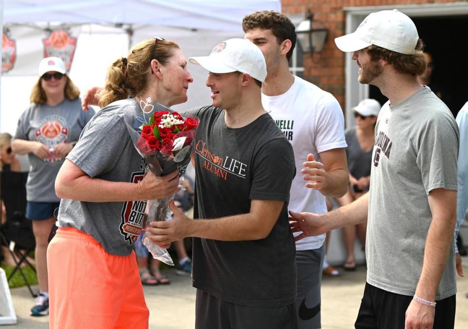 Former North Carolina State women’s basketball player and current college basketball analyst Debbie Antonelli, left, accepts Mother’s Day flowers from sons, Frankie, Joey and Patrick on Sunday, May 14, 2023. Debbie Antonelli was hosting her 24 Hours of Nothing But Net event to help Special Olympics. The event started on Saturday, May 13, 2023. During the 24-hour event, Antonelli shoots and makes 100 free throws every hour.