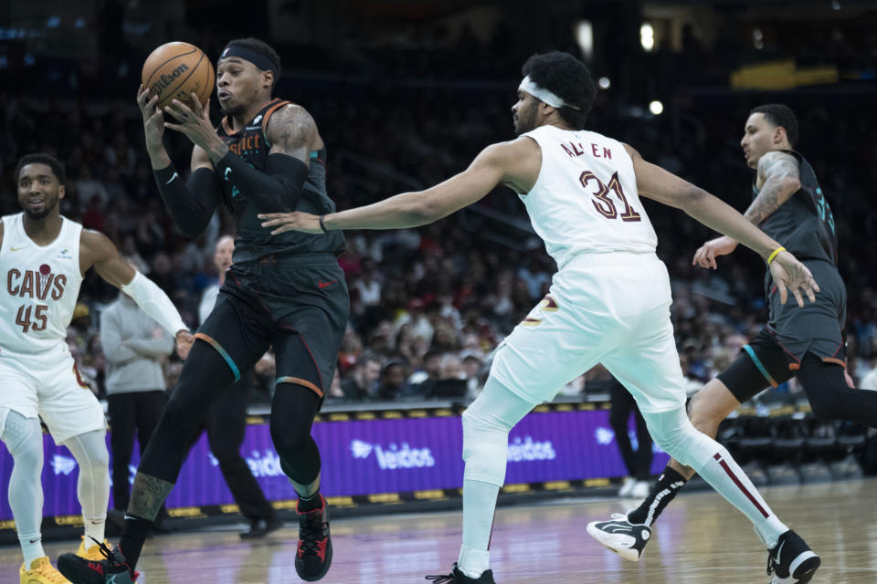 Washington Wizards forward Richaun Holmes, front left, picks up a rebound during the first half of an NBA basketball game against the Cleveland Cavaliers in Washington, Sunday, Feb. 25, 2024. (AP Photo/Manuel Balce Ceneta)