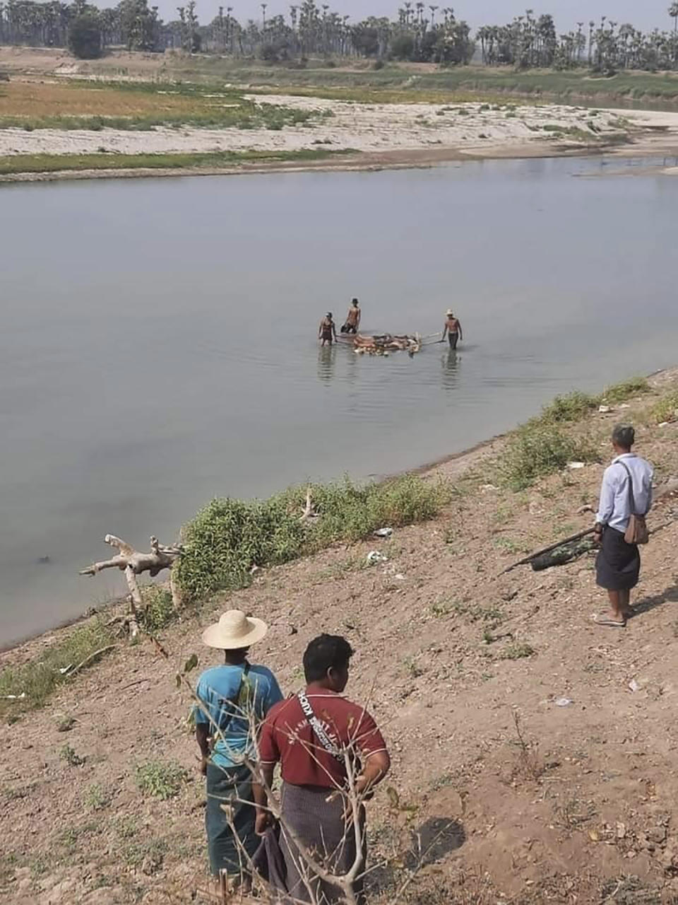 FILE - Men pull a raft with several bodies onboard while crossing the Mu river between Myinmu and Sagaing townships in the Sagaing region in central Myanmar on March 2, 2023. A group of human rights researchers officially launched a website Wednesday, Nov. 1, 2023 that they hope will help get justice for victims of state violence in Myanmar, where one of the world’s less-noticed but still brutal armed struggles is taking place. (UGC via AP)