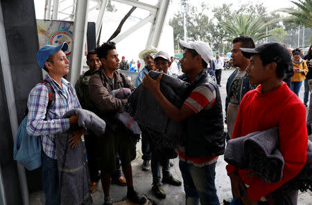 Migrants from Honduras, part of the caravan traveling from Central America en route to the United States, are pictured with blankets delivered after arriving at a sport centre used as a shelter, in Mexico City, Mexico November 4, 2018. REUTERS/Henry Romero