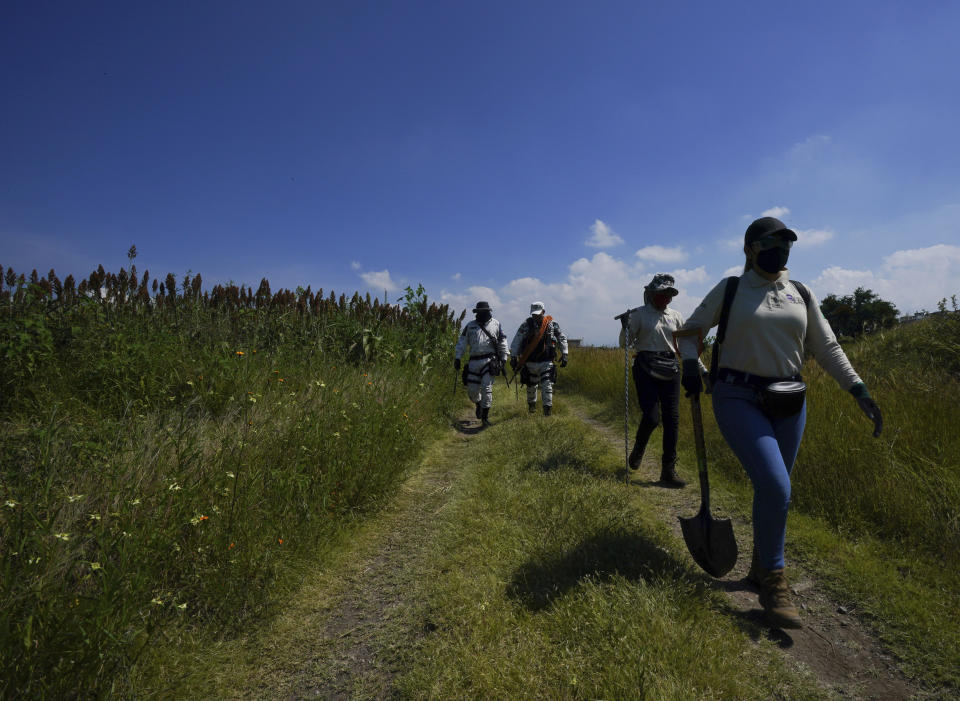 Volunteers and members of National Guard search for disappeared persons on the outskirts of Cuautla, Mexico, Tuesday, Oct. 12, 2021. The government's registry of Mexico’s missing has grown more than 20% in the past year and now approaches 100,000. (AP Photo/Fernando Llano)