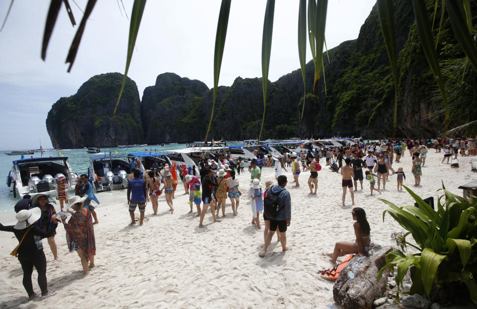 In this photo taken Thursday, May 31, 2018, tourists enjoy the beach on Maya Bay, Phi Phi Leh island in Krabi province, Thailand. Maya Bay will close to tourists indefinitely until its ecosystem returns to its full condition, the Department of National Parks, Wildlife and Plant Conservation said in a Monday announcement published on the Royal Gazette. (AP Photo/Sakchai Lalit)