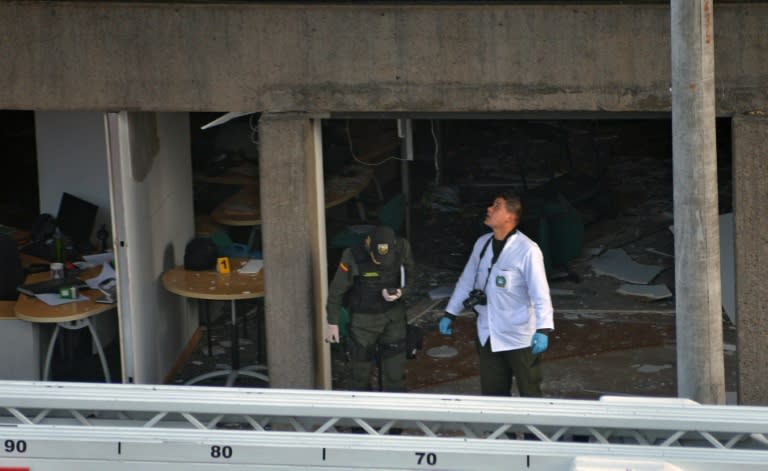 Colombian police officers check the site of an explosion in the financial heart of Bogota on July 2, 2015