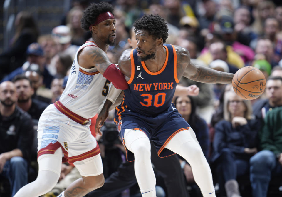 New York Knicks forward Julius Randle, right, is defended by Denver Nuggets guard Kentavious Caldwell-Pope during the second half of an NBA basketball game Wednesday, Nov. 16, 2022, in Denver. (AP Photo/David Zalubowski)