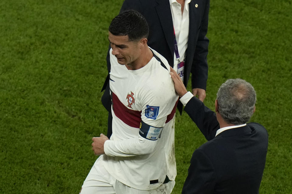 Portugal's Cristiano Ronaldo, left, reacts as he receives a pat from Portugal's head coach Fernando Santos after their loss in the World Cup quarterfinal soccer match against Morocco, at Al Thumama Stadium in Doha, Qatar, Saturday, Dec. 10, 2022. (AP Photo/Alessandra Tarantino)