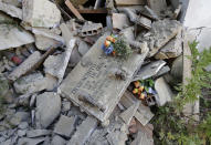 <p>A tombstone is heaped up with rubble of the St. Angelo’s cemetery, in central Italy, Aug. 27, 2016, where graves were cracked after a major earthquake hit the region on Wednesday. (AP Photo/Antonio Calanni) </p>