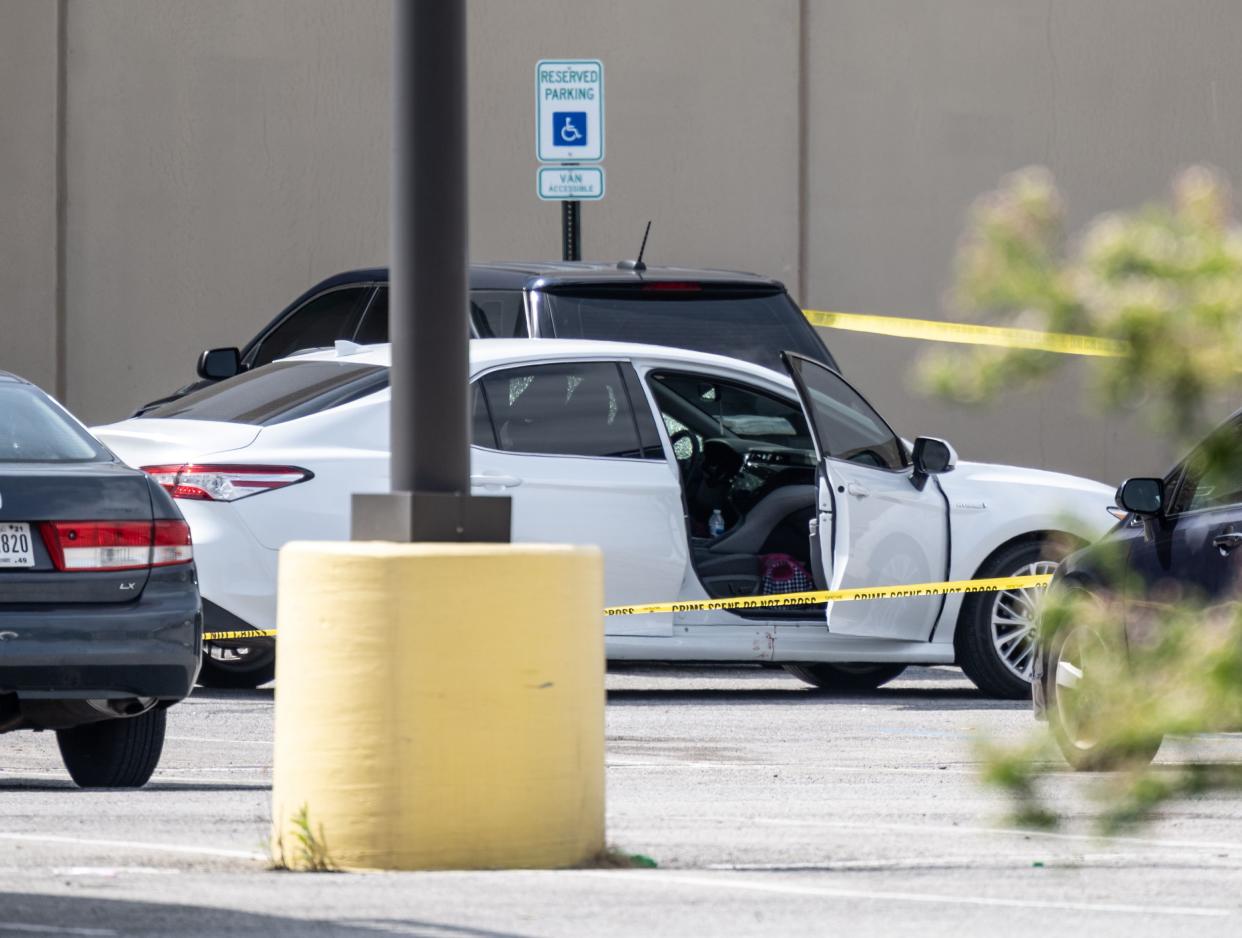 A vehicle with blood on the passenger side door sits vacant in the parking lot of a FedEx SmartPost on Friday in Indianapolis. 