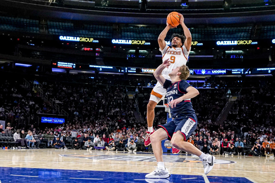 Texas guard Ithiel Horton (9) shoots over UConn guard Cam Spencer (12) during the first half of an NCAA college basketball game in the final of the Empire Classic tournament in New York, Monday, Nov. 20, 2023. (AP Photo/Peter K. Afriyie)