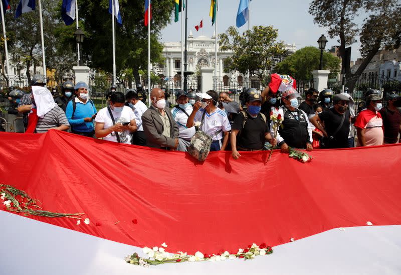 Manifestantes se paran frente al Congreso con una bandera, mientras el legislador peruano Francisco Sagasti fue elegido como presidente interino del país, en Lima,