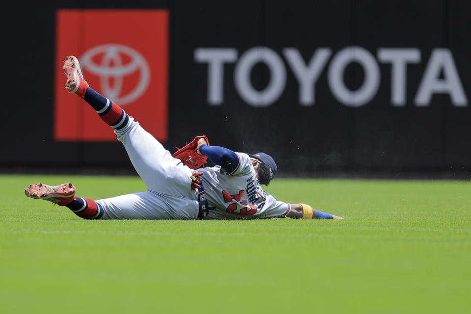 Atlanta Braves' Ronald Acuna Jr. slides to make a catch for an out on a ball hit by Cincinnati Reds' Jonathan India during the first inning of a baseball game in Cincinnati, Sunday, June 27, 2021. (AP Photo/Aaron Doster)