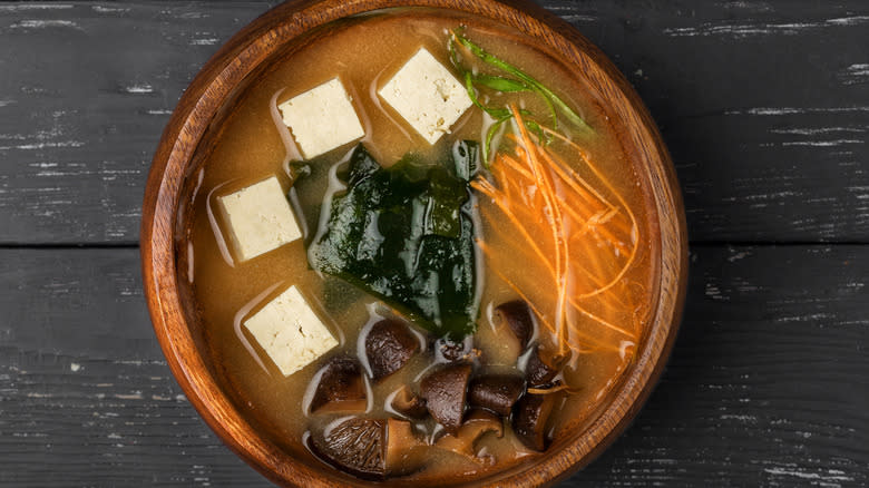 Miso soup with vegetables in wooden bowl