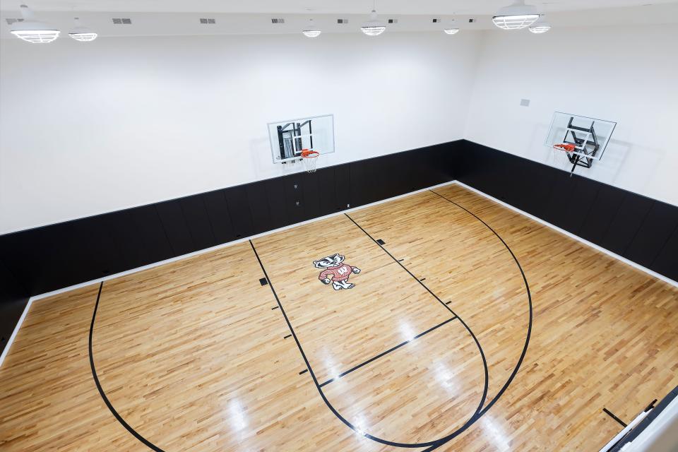 A University of Wisconsin-themed basketball court in the basement of a home.