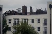 Damage can be seen to the roof of a low-rise block of buildings affected by a fire in Bethnal Green, northeast London, Britain, June 24, 2017. REUTERS/Hannah McKay