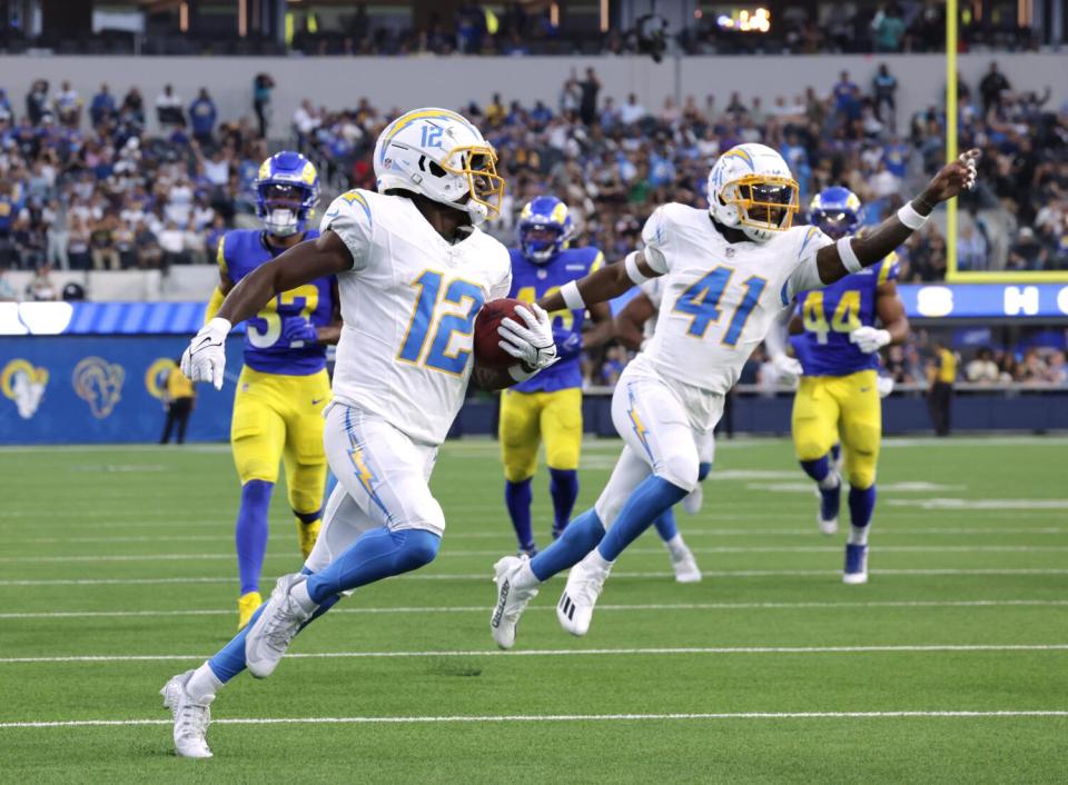 Chargers Derius Davis takes a second quarter punt return for a touchdown as teammate Raheem Layne celebrates.