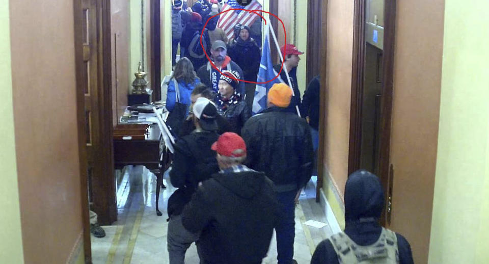 FILE—In this image taken from Capitol building security camera footage and released in a criminal complaint by the U.S. District Court for the District of Columbia, Derek Jancart, circled in red by the source, joins other rioters who stormed the U.S. Capitol on Jan. 6, 2021, in Washington. Jancart, of Ohio, was arrested Tuesday, Feb. 23, and accused of entering the U.S. Capitol after family members and a former coworker identified him in footage captured during the deadly insurrection, according to U.S. District Court documents. At least 10 Ohioans have been charged in connection with the deadly Jan. 6 insurrection at the U.S Capitol after being identified through social media and surveillance footage to the FBI. The group includes people linked to the Oath Keepers militia group who have been indicted on charges that they planned and coordinated with one another in the attack. (U.S. District Court for the District of Columbia via AP, File)