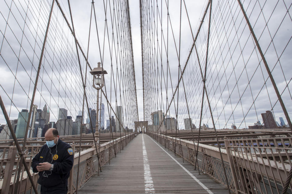 A man wears a face mask for protection against the coronavirus as he walks over the Brooklyn Bridge, Friday, April 10, 2020, in New York. The new coronavirus causes mild or moderate symptoms for most people, but for some, especially older adults and people with existing health problems, it can cause more severe illness or death. (AP Photo/Mary Altaffer)