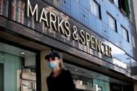 FILE PHOTO: A woman walks past a M&S store at Oxford Street in London