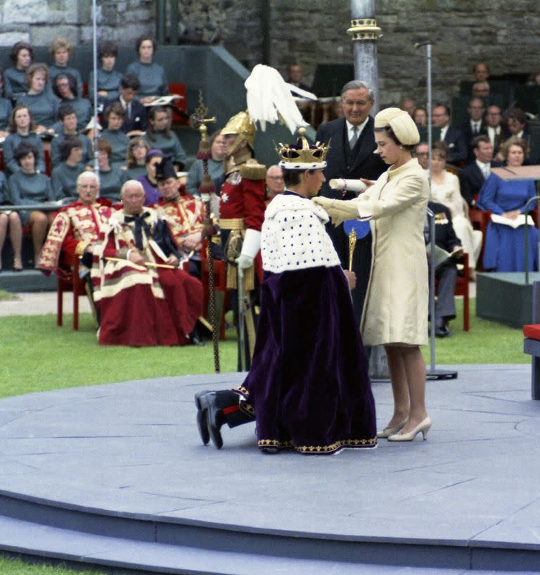 FILE - In this July 1, 1969 file photo, Prince Charles, kneels before his mother, Britain's Queen Eizabeth II, during the investiture ceremony of the Prince of Wales, at Caernafon Castle in Wales. Prince Charles has been preparing for the crown his entire life. Now, that moment has finally arrived. Charles, the oldest person to ever assume the British throne, became king on Thursday Sept. 8, 2022, following the death of his mother, Queen Elizabeth II. (AP Photo, File)