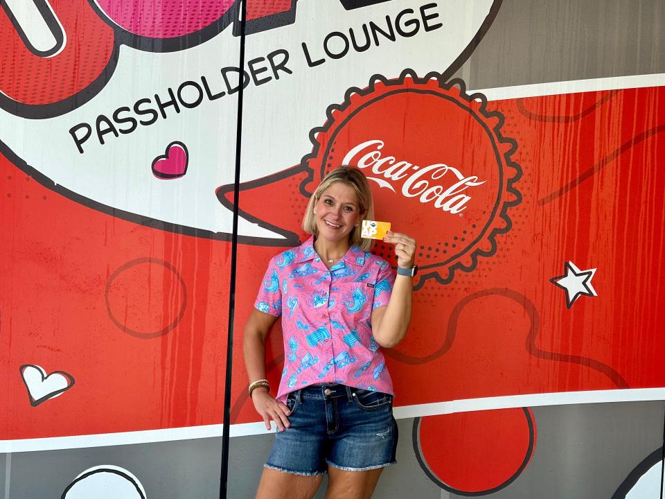 terri posing with her annual pass outside the passholder lounge at universal orlando