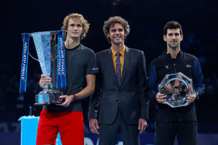 Tennis - ATP Finals - The O2, London, Britain - November 18, 2018 First placed Alexander Zverev of Germany and second placed Novak Djokovic of Serbia pose for photographs with their trophies and former player Gustavo Kuerten after the final Action Images via Reuters/Andrew Couldridge