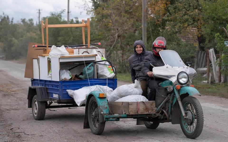 A family moving their few remaining possessions from their destroyed house stop to adjust the load near Oleksandrivka, Donetsk - Julian Simmonds for the Telegraph
