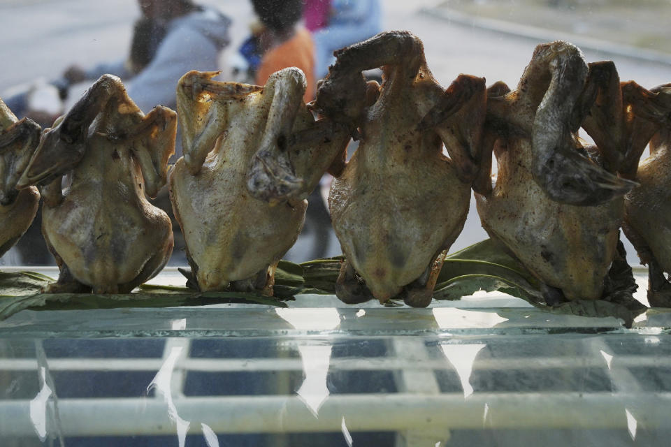 Grilled chickens display for selling in a shop outside Phnom Penh, Cambodia, Monday, Feb. 12, 2024. Cambodia reports a new bird flu case, the brother of a 9-year-old who died of the virus last week. (AP Photo/Heng Sinith)