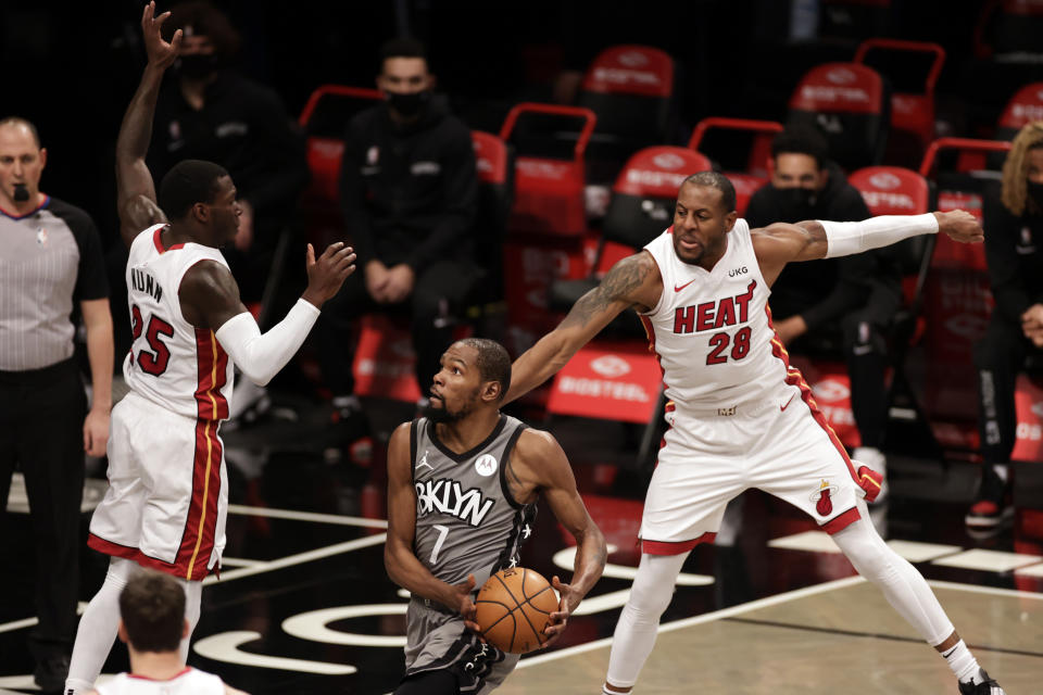 Brooklyn Nets forward Kevin Durant (7) drives to the basket between Miami Heat forward Andre Iguodala (28) and guard Kendrick Nunn during the first half of an NBA basketball game Monday, Jan. 25, 2021, in New York. (AP Photo/Adam Hunger)