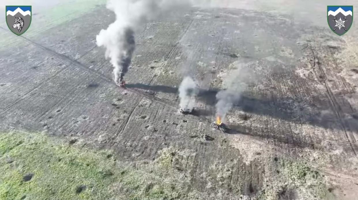 A still taken from video posted by Ukraine's 8th battalion of the 10th mountain assault brigade "Edelweiss," showing three smoking armored vehicles in a field.