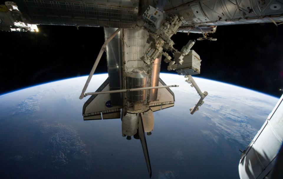 NASA image acquired July 19, 2011 - Silhouetted against the Earth, Atlantis flies into the rising Sun in this photograph taken by an astronaut on the International Space Station on July 19, 2011. On July 20, the shuttle undocked from the station for the final time and began preparations to return home. During their 13 days in space, the shuttle astronauts supplied the International Space Station with a new logistics module, tested tools, technologies, and techniques to refuel satellites in space, and collected old equipment from the space station. Credit: NASA Earth Observatory  