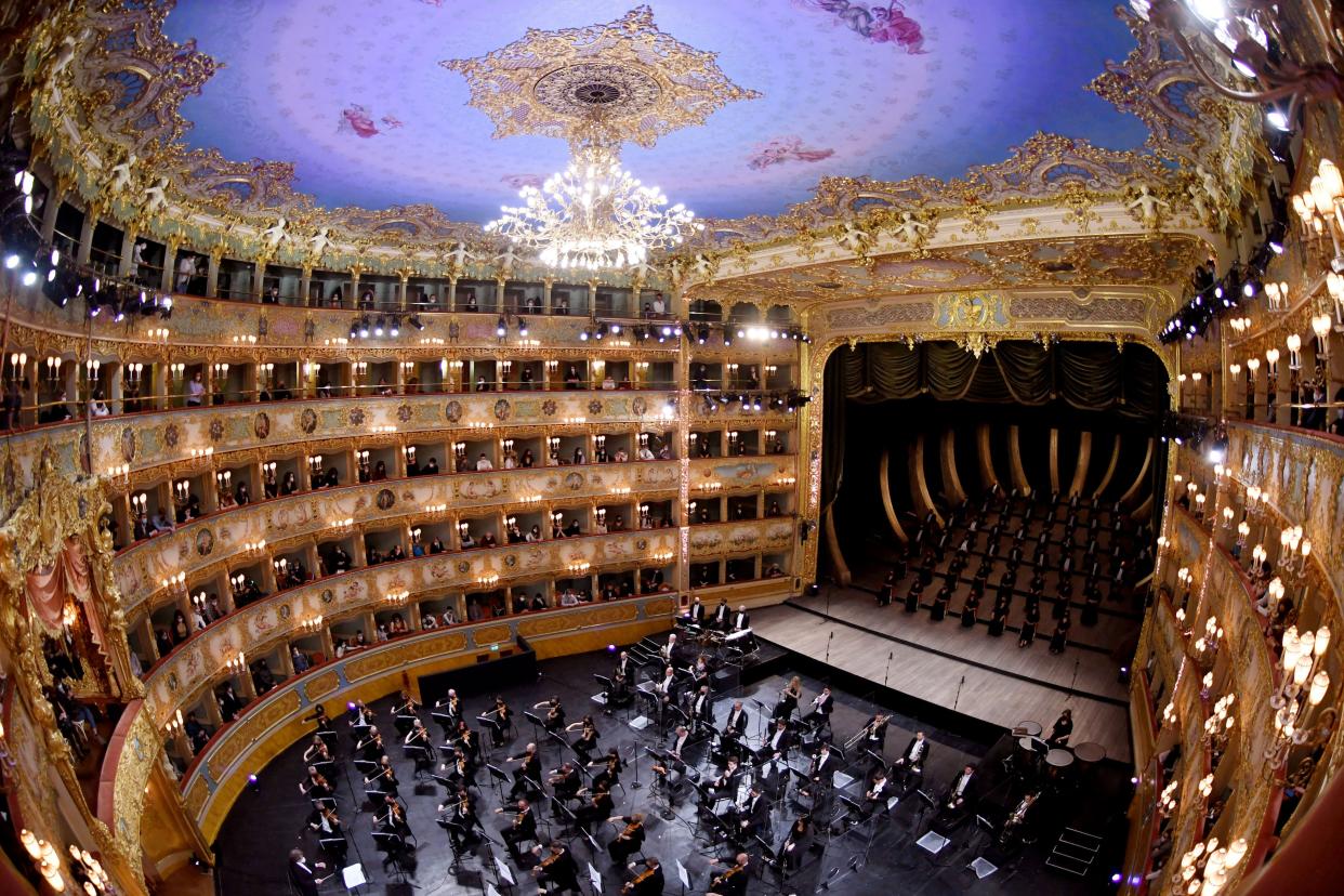 This photograph taken with a fish-eye effect shows musicians and chorus of the Fenice Opera theatre perform the Verdi e la Fenice (Verdi and the Fenice) to mark the reopening of the Fenice Opera theater in Venice on April 26, 2021, as bars, restaurants, cinemas and concert halls partially reopen across Italy. This comes as parliament debates the government's 220-billion-euro ($266-billion) EU-funded recovery plan. After months of stop-start restrictions imposed to manage its second and third waves of COVID-19, Italy hopes this latest easing will mark the start of something like a normal summer.