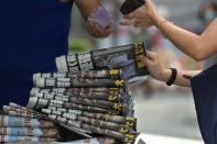 People buy Apple Daily at a news stand at a downtown street in Hong Kong Friday, June 18, 2021. The pro-democracy paper increased its print run to 500,000 copies on Friday, a day after police arrested five top editors and executives and froze $2.3 million in assets linked to the media company. (AP Photo/Vincent Yu)