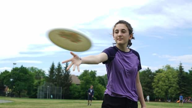 Karina Dobson tosses a disc around with friends at Brian Kearns Fields in central Ottawa on June 11, 2021. Dobson says she's looking forward to playing ultimate again as Ontario loosens its COVID-19 restrictions. (Matthew Kupfer/CBC - image credit)