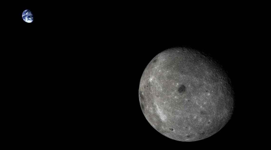 La face cachée de la Lune, avec la Terre lointaine en arrière-plan, est visible sur cette photo prise par le module en orbite autour de la Lune de la mission Chang’e 5-T1 en 2014.