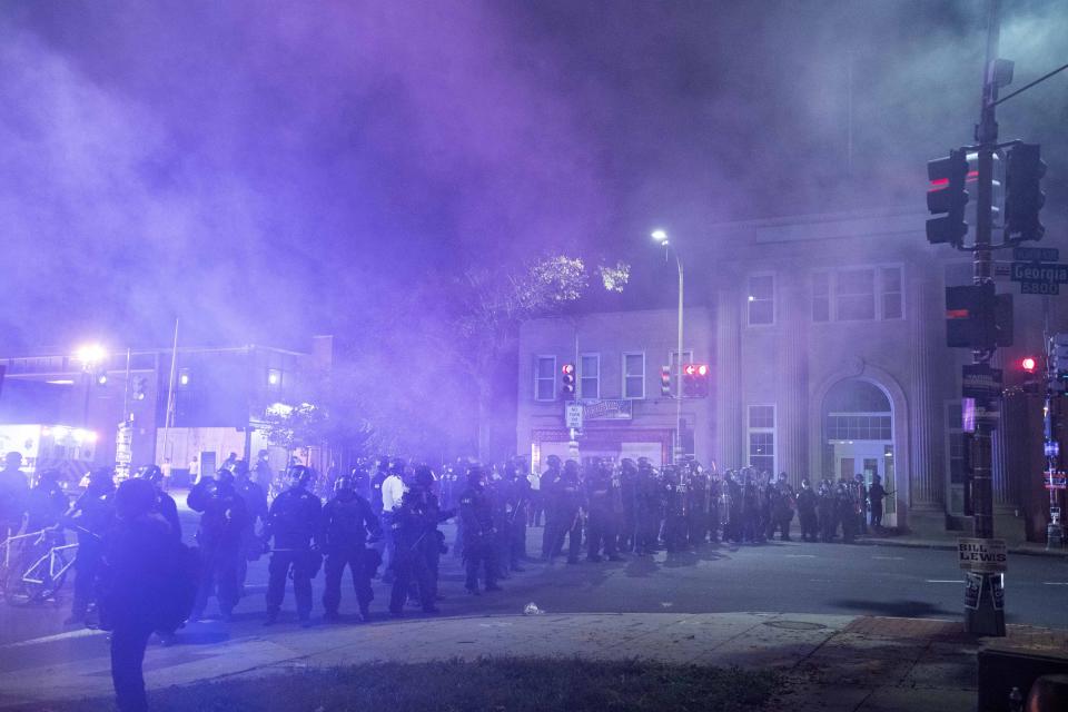 Washington Metropolitan Police Department police officers shoot smoke projectiles at demonstrators outside of the fourth district police station in Washington, Wednesday, Oct. 28, 2020. Demonstrators gathered at the police station in protest over a fatal a crash involving a moped driver who died when he police were attempting to pull him over. The crash happened last Friday. (AP Photo/Jose Luis Magana)