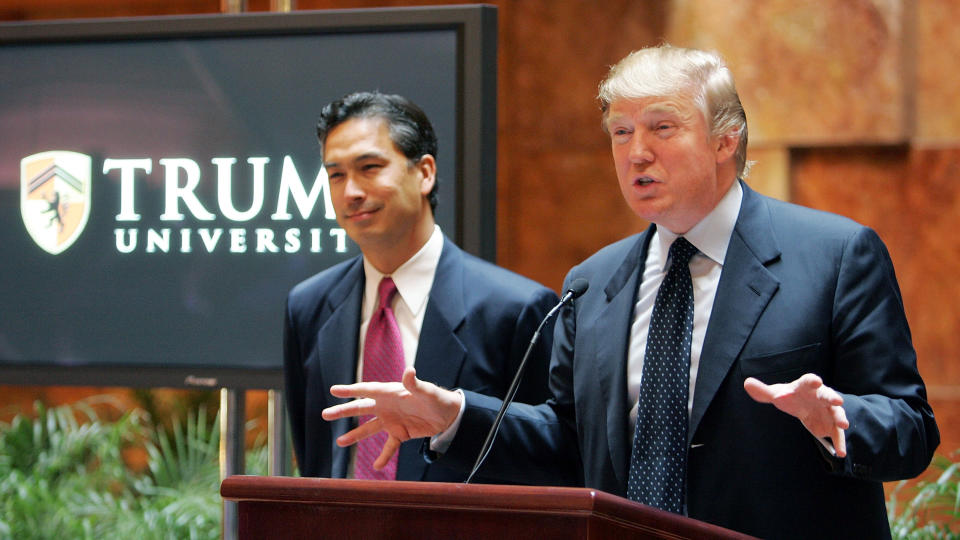 NEW YORK - MAY 23:  Real estate mogul Donald Trump (R) speaks as university president Michael Sexton (L) looks on during a news conference announcing the establishment of Trump University May 23, 2005 in New York City. Trump University will consist of on-line courses, CD-ROMS and other learning programs for business professionals.  (Photo by Mario Tama/Getty Images)