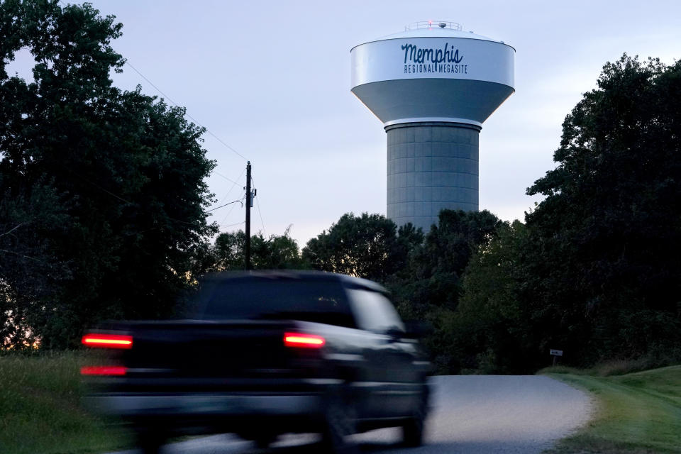 FILE - A truck drives down a rural road near a water tower marking the location of the Memphis Regional Megasite on Sept. 24, 2021, in Stanton, Tenn. Ford Motor Co. and a South Korean company would have to create more than 5,000 full-time jobs at a planned electric pickup truck factory and battery manufacturing plant in Stanton or pay back at least part of a $500 million state grant for the project, according to a lease approved Thursday, Feb. 17, 2022, by a regional board. (AP Photo/Mark Humphrey, File)